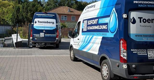 Einsatzfahrzeuge eines trocknung.de Partnerbetriebs vor einem Wohnhaus